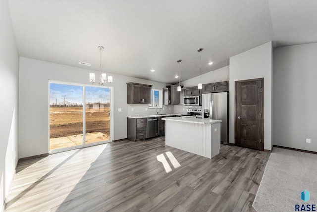 kitchen with sink, a center island, hanging light fixtures, and appliances with stainless steel finishes