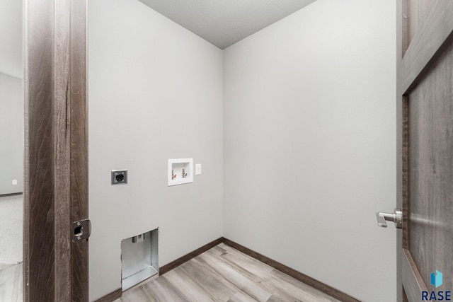 clothes washing area featuring hookup for an electric dryer, light wood-type flooring, and washer hookup