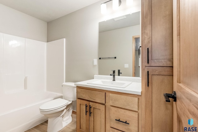 full bathroom featuring hardwood / wood-style flooring, toilet, washtub / shower combination, and vanity