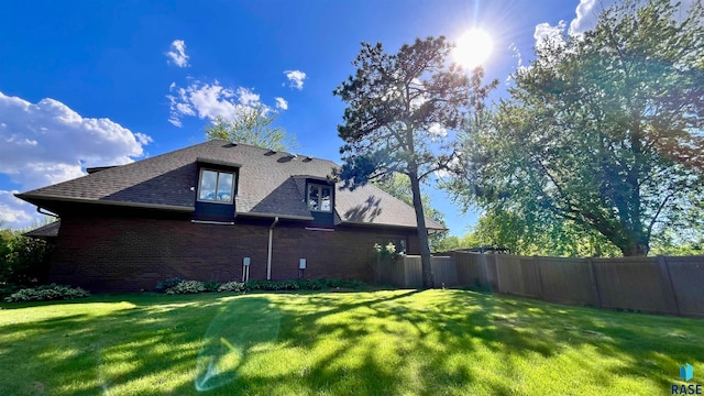 view of side of home with a yard