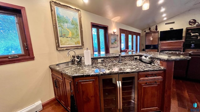 kitchen with lofted ceiling, dark hardwood / wood-style flooring, dark stone counters, wine cooler, and baseboard heating