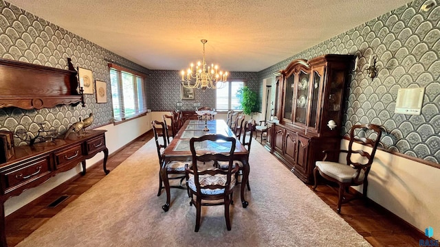 dining room with a notable chandelier, plenty of natural light, and a textured ceiling