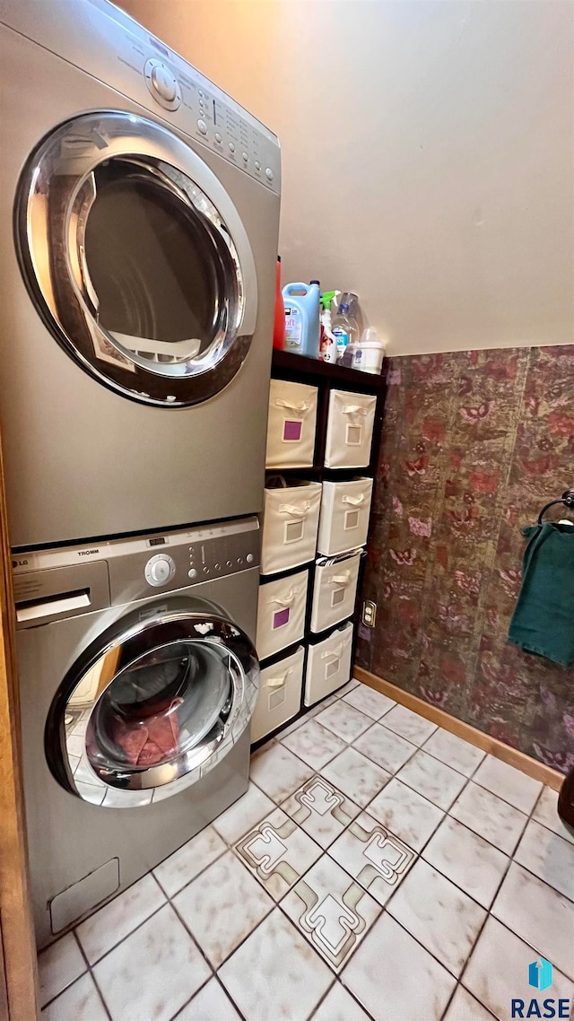 laundry area featuring stacked washer and dryer and light tile floors