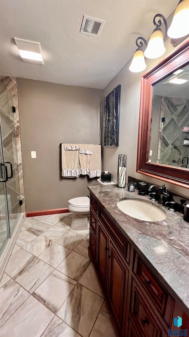 bathroom featuring tile flooring, oversized vanity, toilet, and a shower with door