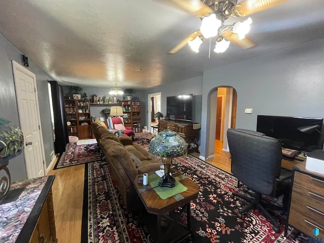 living room with hardwood / wood-style flooring, ceiling fan, and a textured ceiling