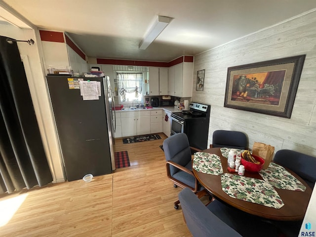 kitchen with sink, light hardwood / wood-style floors, white cabinetry, and appliances with stainless steel finishes