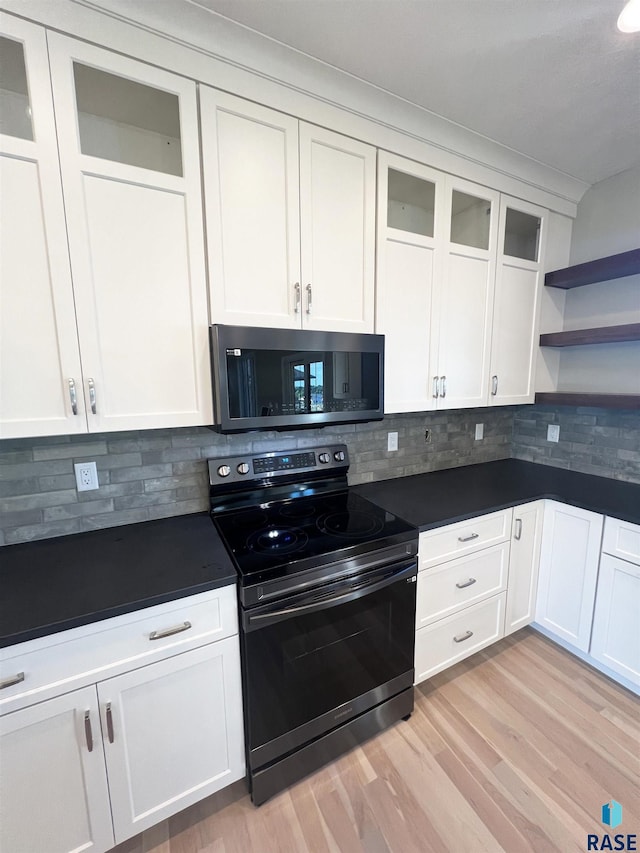 kitchen with white cabinets, stainless steel appliances, and tasteful backsplash