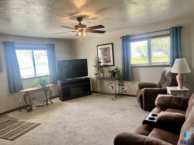 carpeted living room with plenty of natural light, ceiling fan, and a textured ceiling