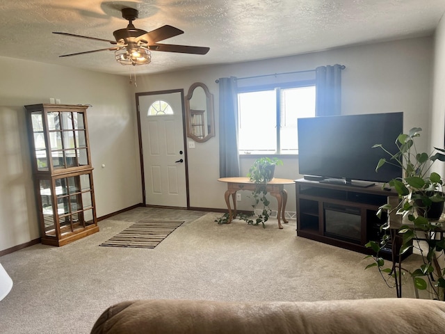 entryway with carpet, ceiling fan, and a textured ceiling