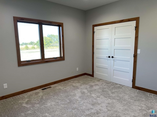 unfurnished bedroom featuring carpet flooring and a closet