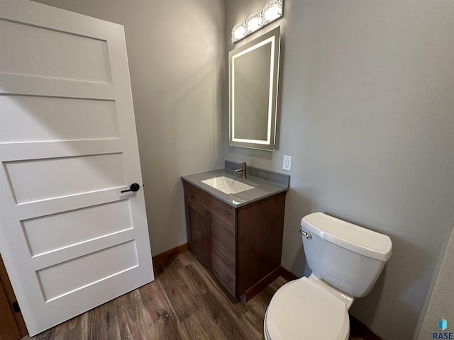 bathroom with hardwood / wood-style flooring, vanity, and toilet