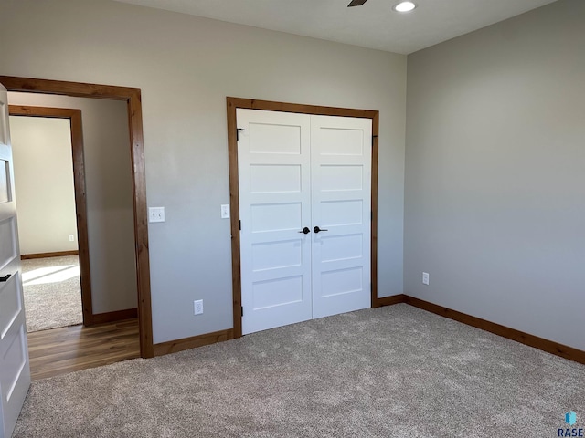 unfurnished bedroom featuring dark colored carpet, ceiling fan, and a closet