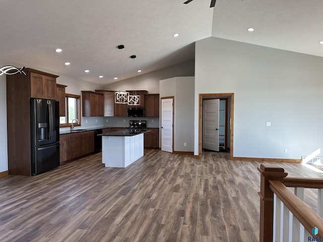 kitchen featuring pendant lighting, black appliances, sink, a kitchen island, and dark hardwood / wood-style flooring