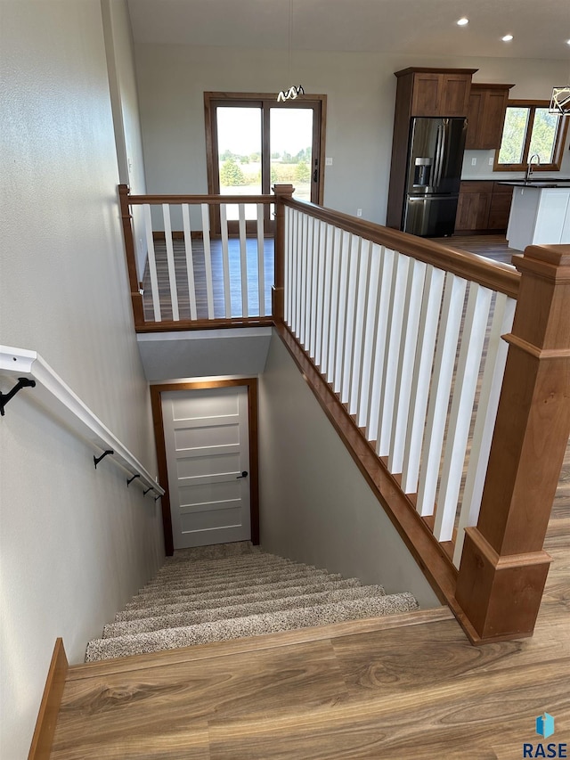 staircase featuring sink and wood-type flooring