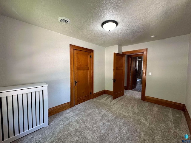 unfurnished bedroom with carpet flooring and a textured ceiling