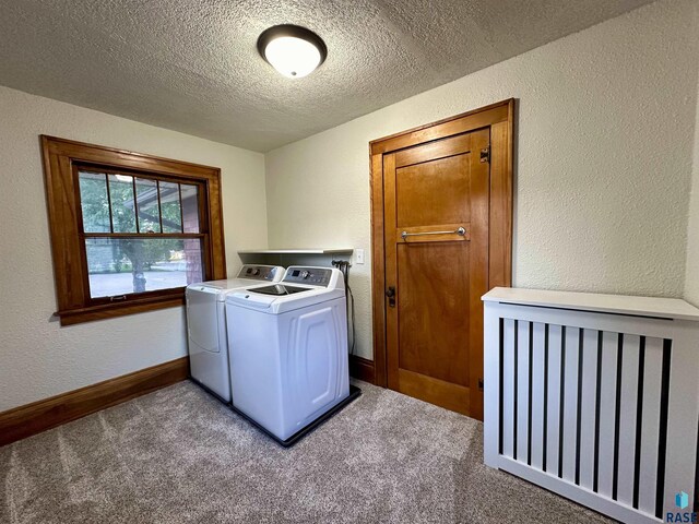 laundry room with separate washer and dryer, a textured ceiling, and carpet flooring