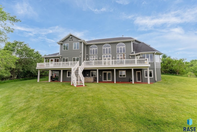 rear view of property with a wooden deck and a lawn