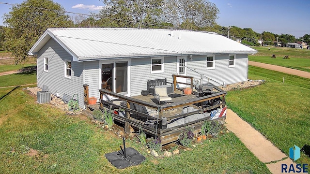 back of property featuring a wooden deck, a yard, and central AC