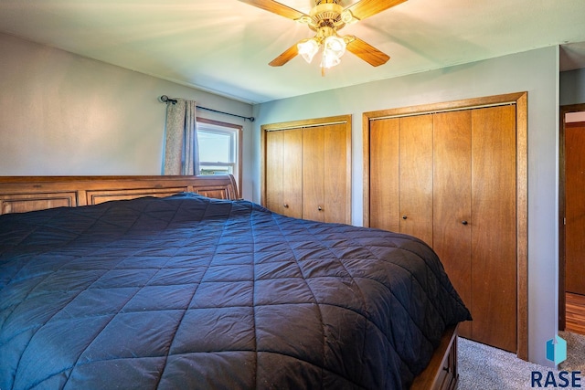 carpeted bedroom with multiple closets and ceiling fan