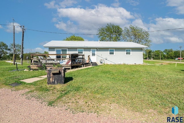 rear view of property with a deck and a lawn