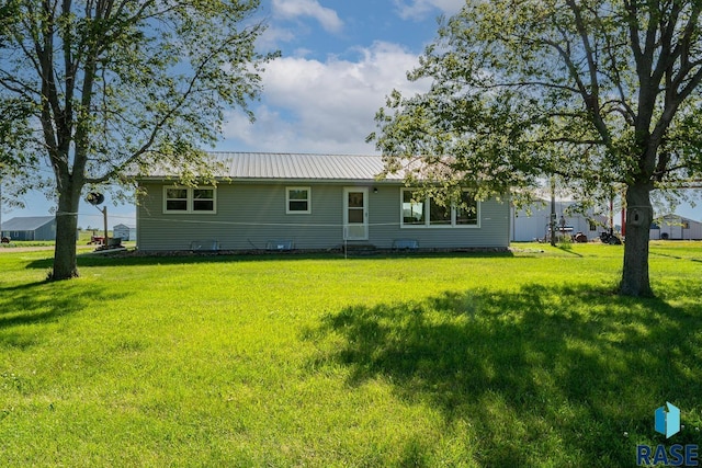 rear view of house featuring a yard