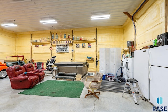 garage with washing machine and dryer and white fridge