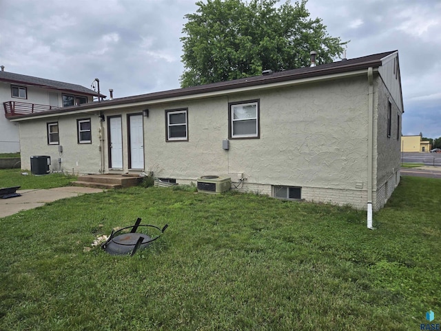 rear view of house featuring a lawn and cooling unit