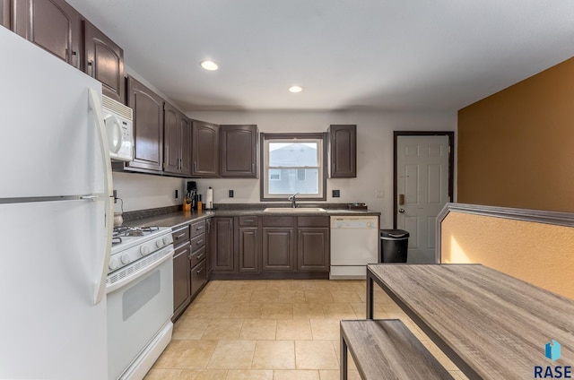 kitchen featuring dark brown cabinetry, white appliances, and sink