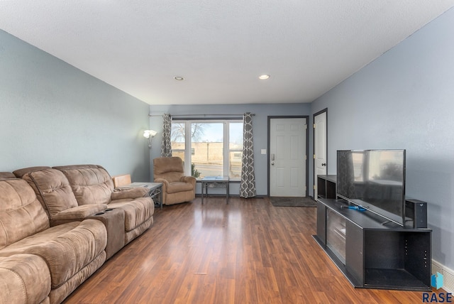 living room with dark hardwood / wood-style floors and a textured ceiling