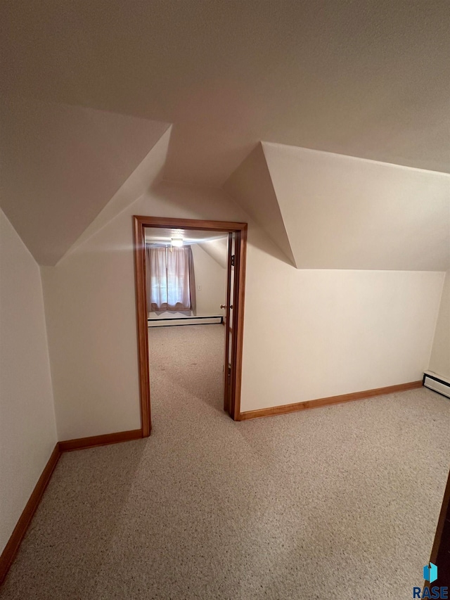 bonus room with a baseboard heating unit, carpet floors, and vaulted ceiling