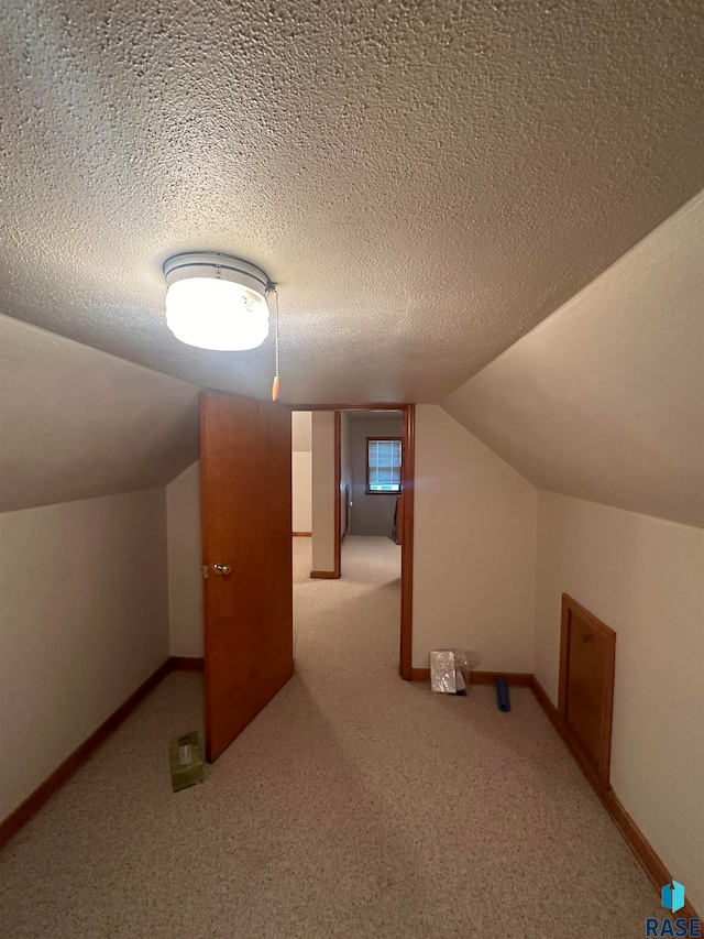 bonus room with a textured ceiling, carpet flooring, and lofted ceiling