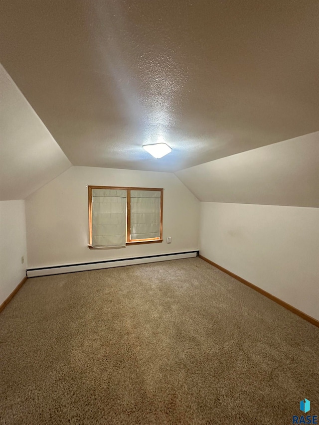 additional living space featuring carpet flooring, vaulted ceiling, a baseboard radiator, and a textured ceiling