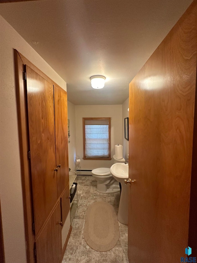 bathroom featuring tile flooring, a baseboard radiator, and toilet