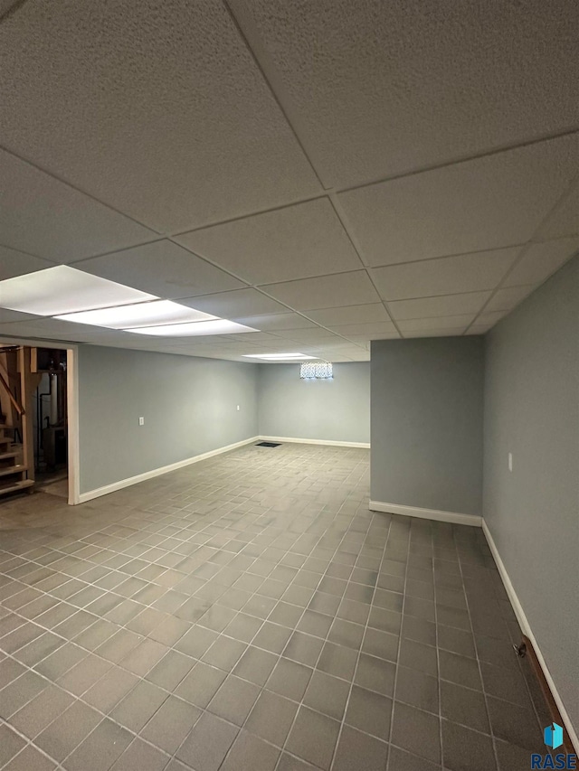 basement with tile flooring and a drop ceiling