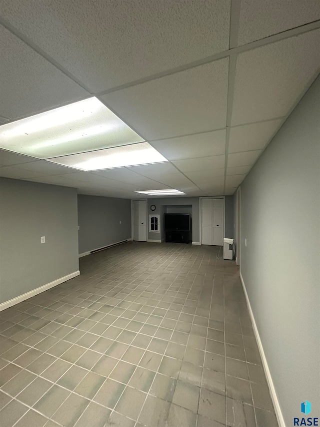 basement featuring tile floors and a drop ceiling