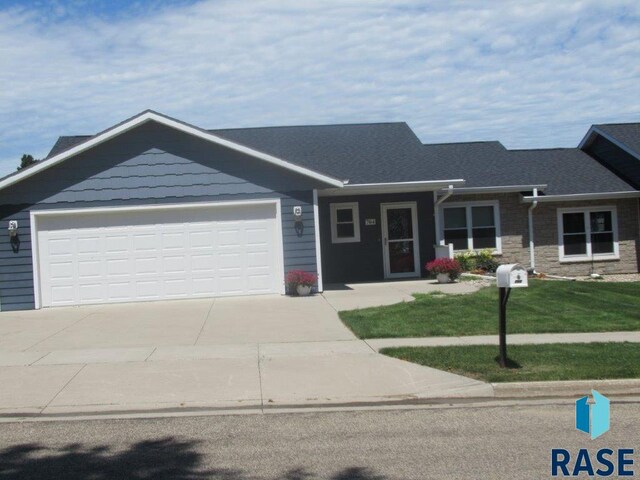 ranch-style house with a garage and a front yard