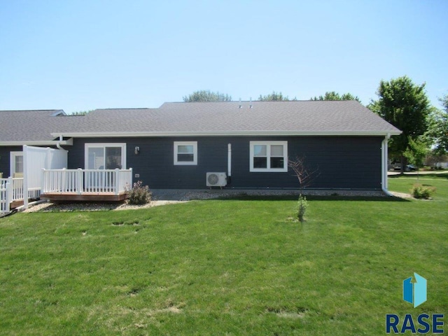 back of property with a deck and a lawn