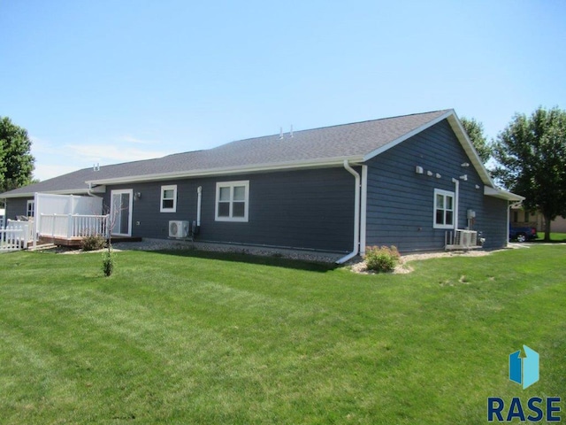 rear view of property featuring a yard and central AC unit