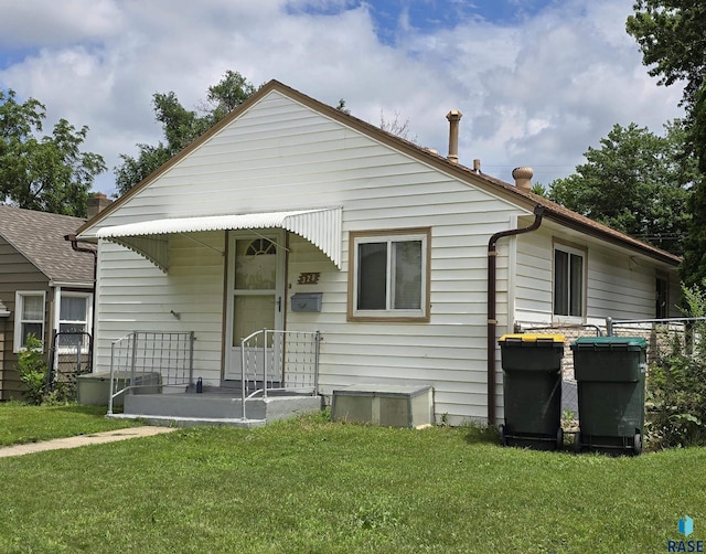 rear view of property with a lawn