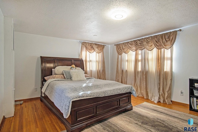 bedroom with a textured ceiling and hardwood / wood-style flooring