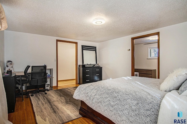 bedroom with wood-type flooring and a textured ceiling