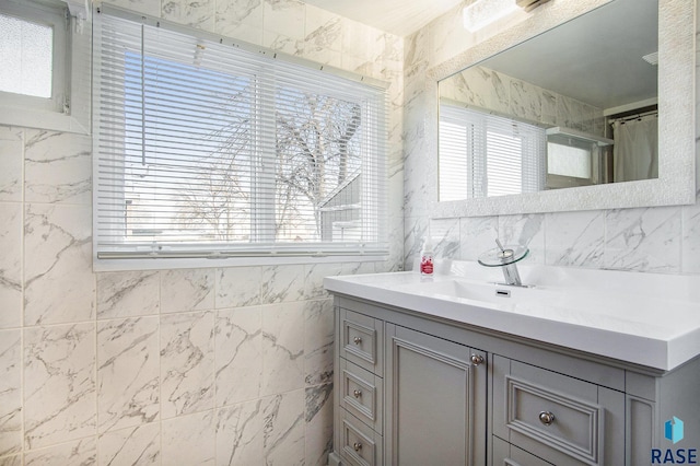 bathroom featuring vanity and tile walls