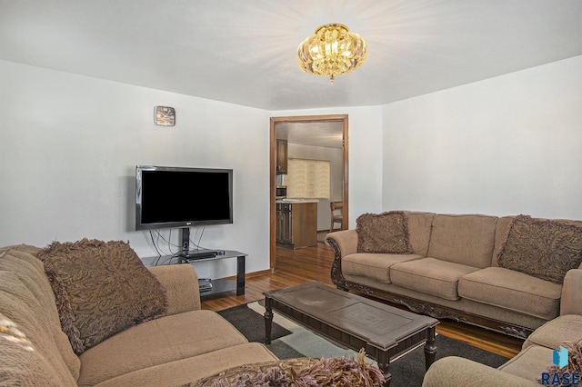 living room featuring wood-type flooring and an inviting chandelier