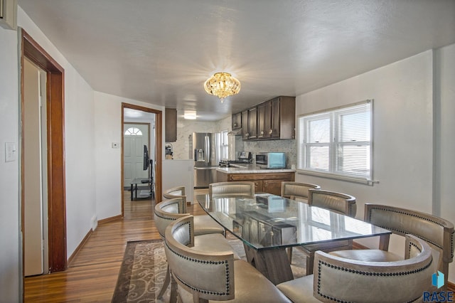 dining room with dark hardwood / wood-style flooring and a chandelier