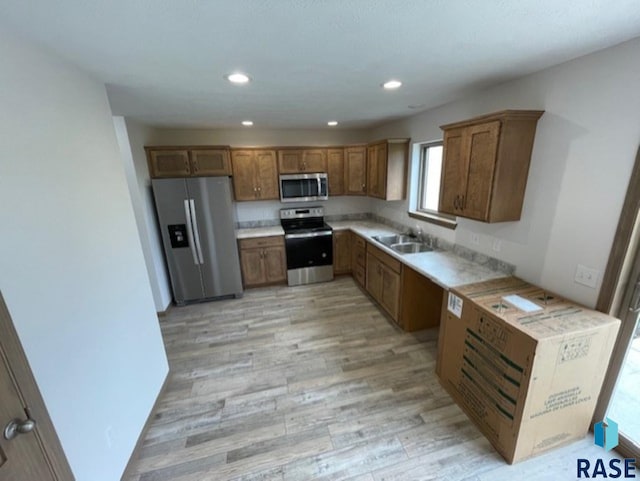 kitchen featuring light wood-type flooring, sink, and appliances with stainless steel finishes