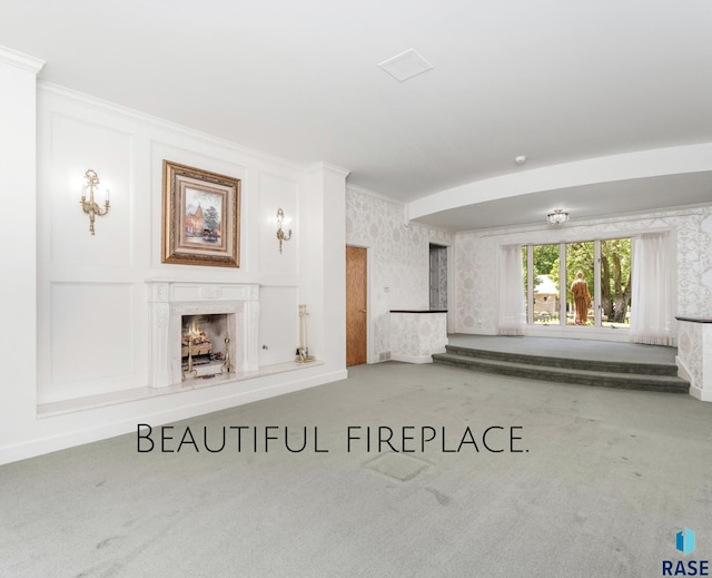 unfurnished living room with carpet flooring and ornamental molding