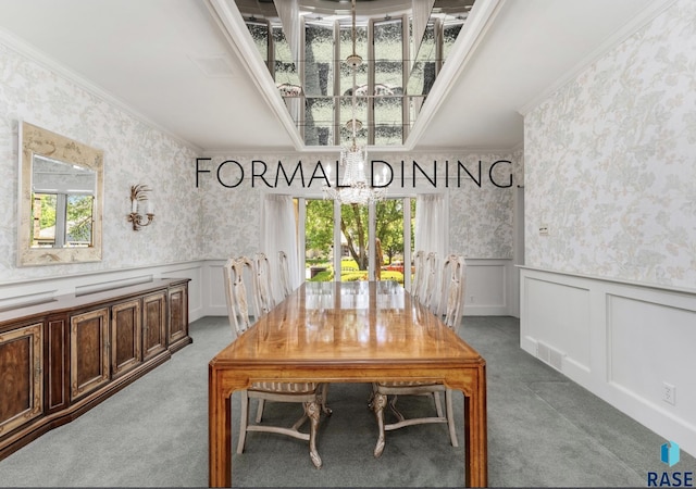 unfurnished dining area featuring light carpet, crown molding, and a notable chandelier