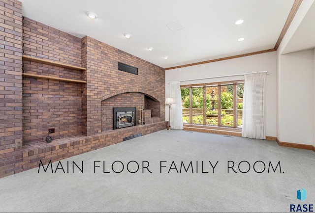 unfurnished living room featuring a brick fireplace, ornamental molding, and carpet flooring