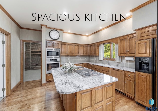 kitchen featuring backsplash, light wood-type flooring, built in appliances, a kitchen island, and sink