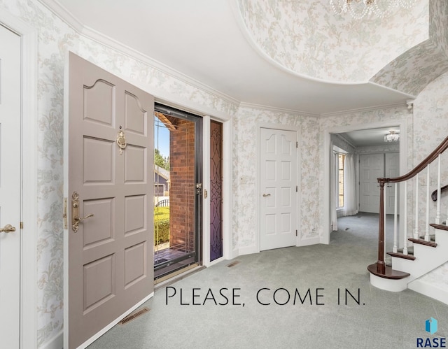 carpeted foyer with crown molding